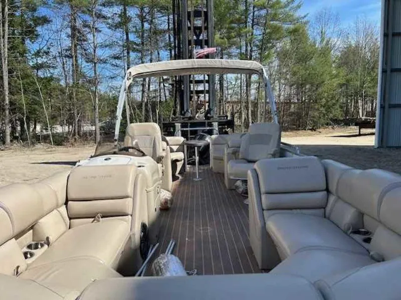 Slide: The Image of 2018 Berkshire 24RFX CTS pontoon boat with beige seating and canopy in a wooded area. - 5