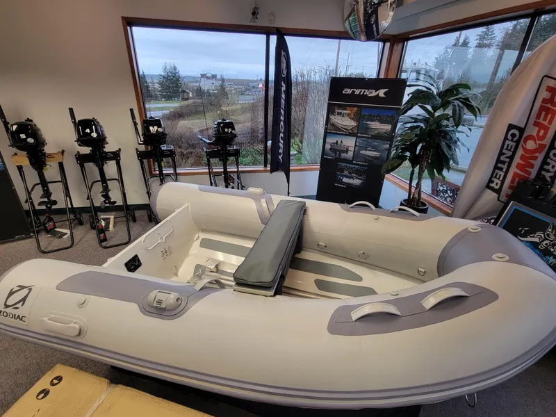 The Image of 2024 Zodiac Cadet RIB Alu 270 inflatable boat displayed in showroom with outboard motors. - 0
