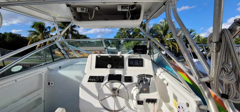 Slide: The Image of 2000 Pro-Line 29 Walkaround boat cockpit with Garmin navigation, tropical background. - 12