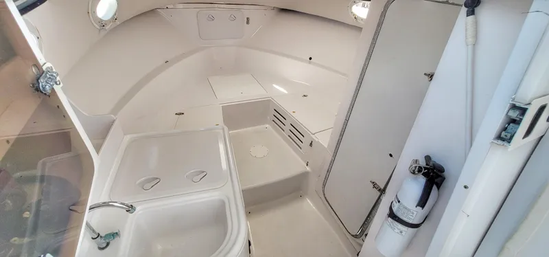 Slide: The Image of 2000 Pro-Line 29 Walkaround boat interior with sink and storage compartments. - 4