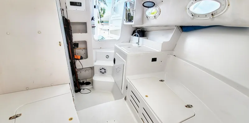 Slide: The Image of 2000 Pro-Line 29 Walkaround boat interior with white cabinetry and portholes. - 5