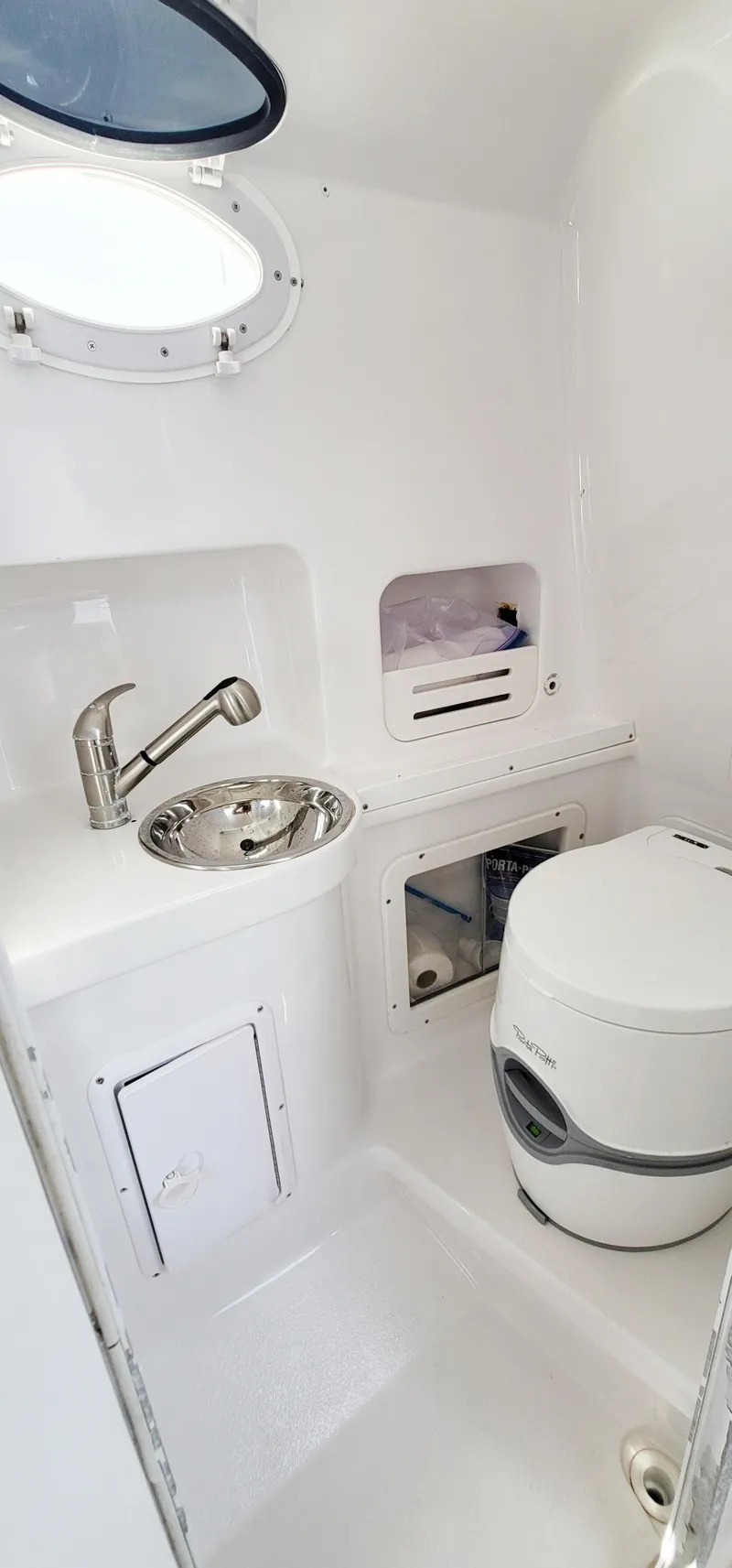 Slide: The Image of 2000 Pro-Line 29 Walkaround boat bathroom with sink, toilet, and porthole window. - 7