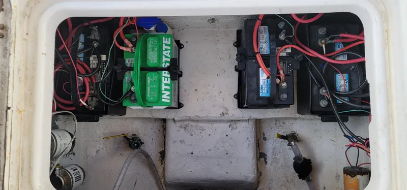 Slide: The Image of Battery compartment of a 2000 Pro-Line 29 Walkaround boat with multiple batteries and wiring. - 9