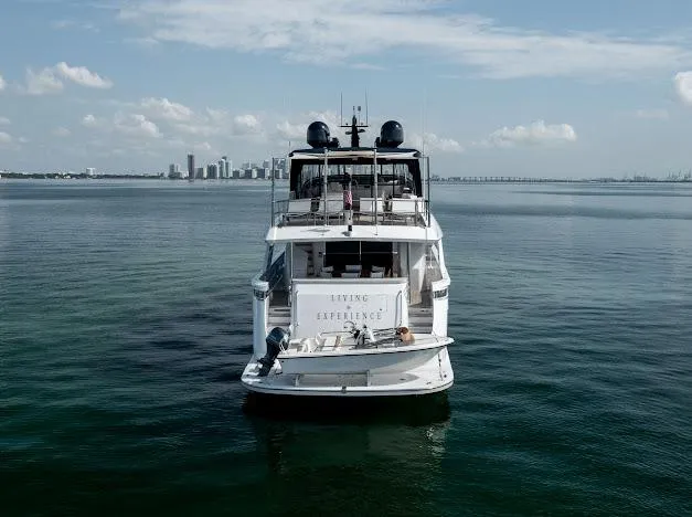 Slide: The Image of Hatteras 100 Raised Pilothouse 2015 yacht on calm waters with city skyline in background. - 10