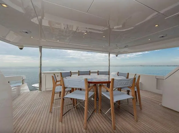 Slide: The Image of Outdoor dining area on 2015 Hatteras 100 Raised Pilothouse yacht with ocean view. - 18
