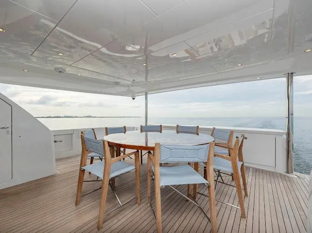 Slide: The Image of Outdoor dining area on 2015 Hatteras 100 Raised Pilothouse yacht with ocean view. - 19