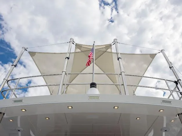 Slide: The Image of 2015 Hatteras 100 Raised Pilothouse yacht with sunshade and American flag. - 23