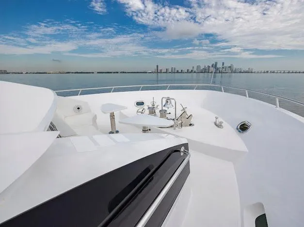 Slide: The Image of Bow view of 2015 Hatteras 100 Raised Pilothouse yacht with city skyline in background. - 24