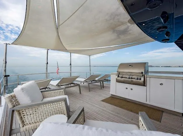 Slide: The Image of Spacious deck of 2015 Hatteras 100 Raised Pilothouse yacht with lounge chairs and grill. - 25