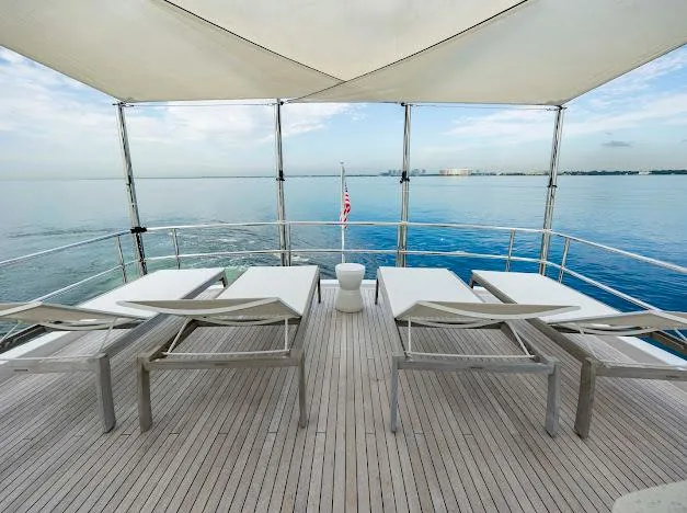 Slide: The Image of Luxury deck of 2015 Hatteras 100 Raised Pilothouse yacht with sun loungers and ocean view. - 27