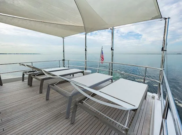 Slide: The Image of Sun deck of 2015 Hatteras 100 Raised Pilothouse yacht with lounge chairs and ocean view. - 28