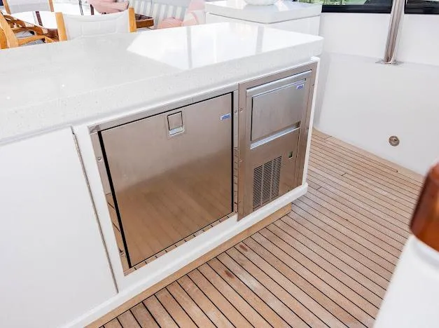 Slide: The Image of Outdoor kitchen area on a 2015 Hatteras 100 Raised Pilothouse yacht with stainless steel appliances. - 38
