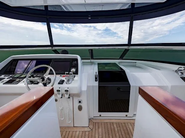 Slide: The Image of 2015 Hatteras 100 Raised Pilothouse yacht helm with modern navigation equipment and panoramic windows. - 43
