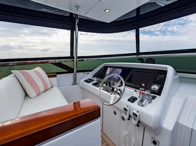 Slide: The Image of 2015 Hatteras 100 Raised Pilothouse yacht helm with modern navigation equipment and seating. - 44