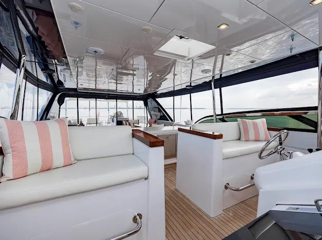 Slide: The Image of Interior of 2015 Hatteras 100 Raised Pilothouse yacht with white seating and striped cushions. - 47