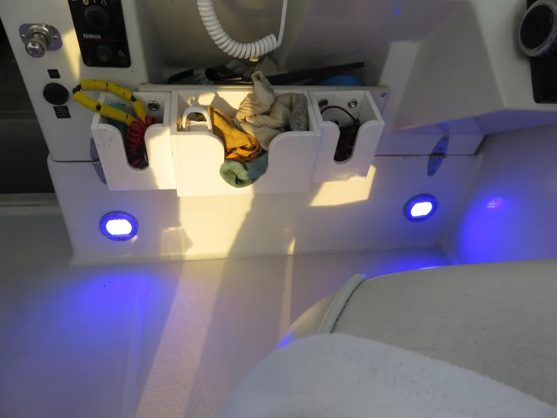 Slide: The Image of Interior of 1999 Stamas 250 Express boat with storage compartments and blue LED lights. - 12