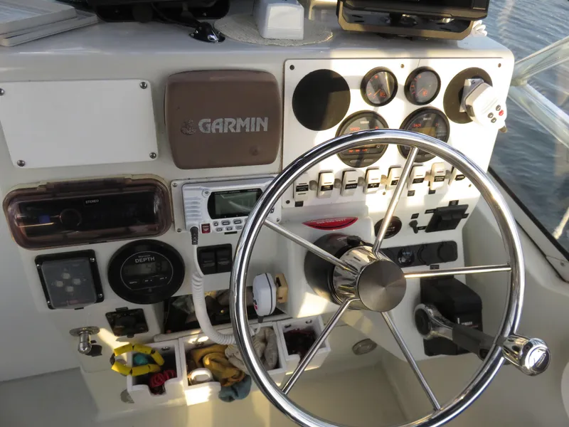 Slide: The Image of Control panel of a 1999 Stamas 250 Express boat with steering wheel and gauges. - 17