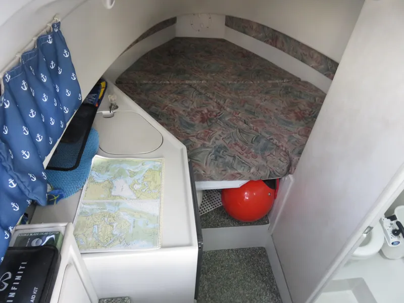 Slide: The Image of 1999 Stamas 250 Express cabin interior with bed, sink, and nautical maps. - 22