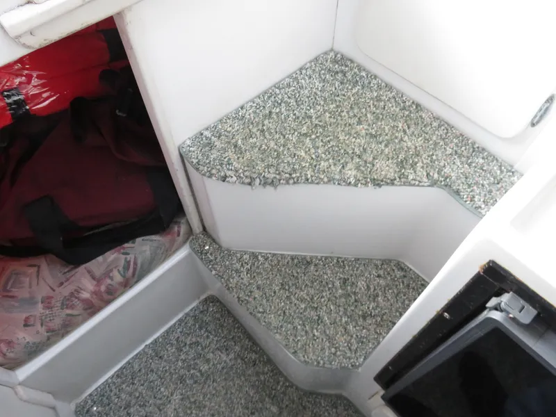 Slide: The Image of Interior steps of a 1999 Stamas 250 Express boat with carpeted surfaces. - 25