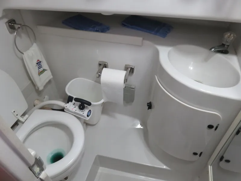 Slide: The Image of 1999 Stamas 250 Express boat bathroom with toilet, sink, and storage. - 4