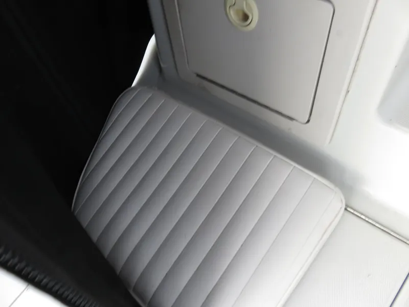 Slide: The Image of 1999 Stamas 250 Express boat interior with cushioned seat and storage compartment. - 7