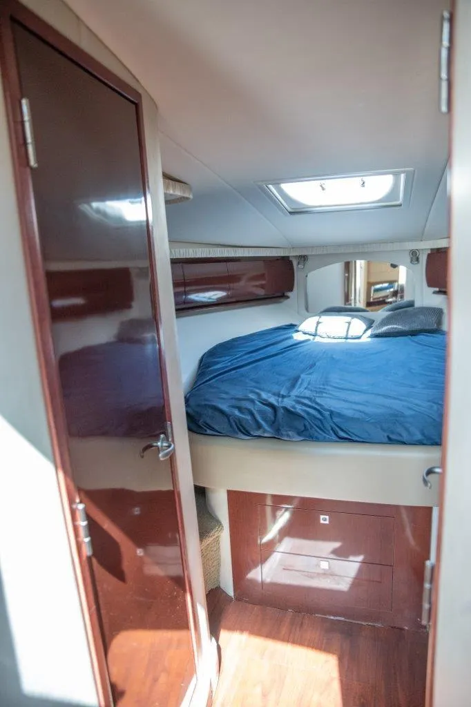 Slide: The Image of 2008 Sea Ray 44 Sundancer cabin with bed, skylight, and wooden finishes. - 15