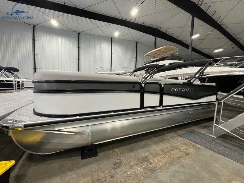 Slide: The Image of 2024 Premier Sunsation 230 RE pontoon boat displayed in indoor marina. - 2