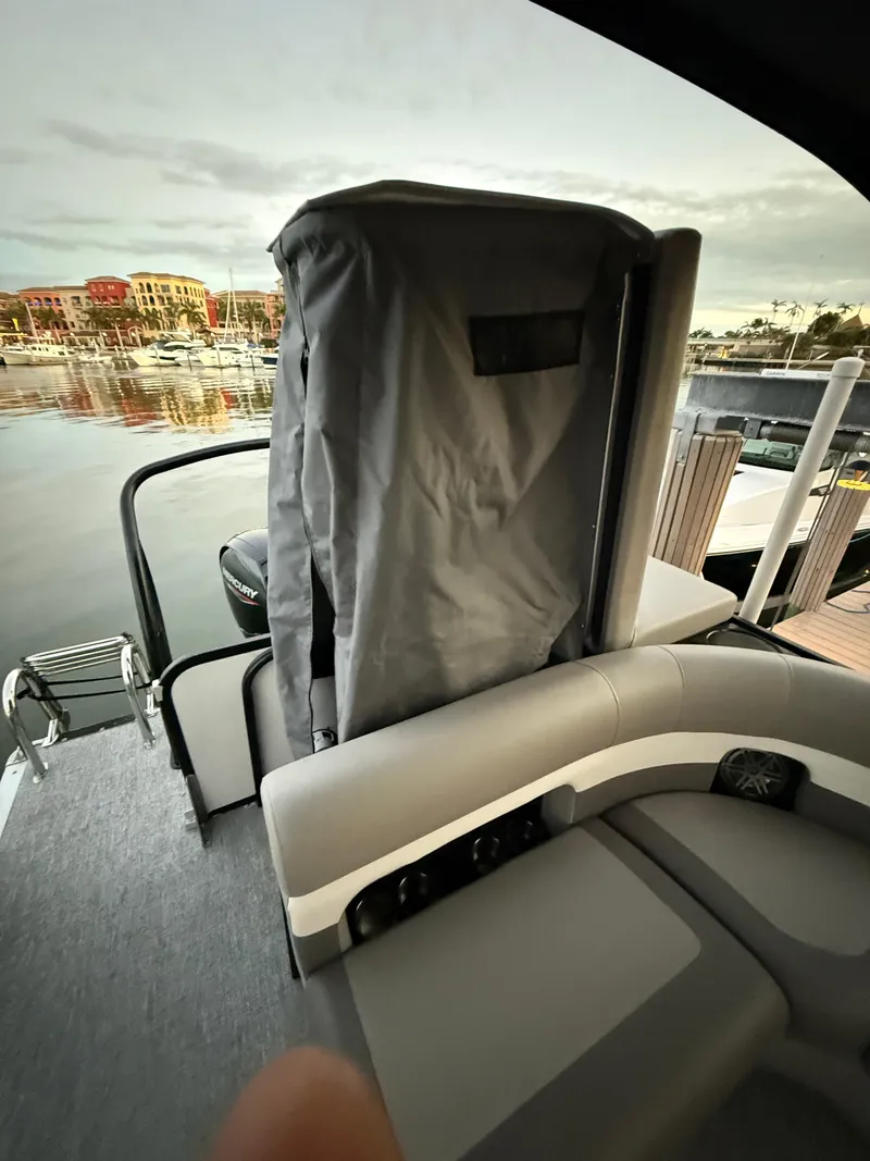 Slide: The Image of 2024 Premier Sunsation 230 RE pontoon boat interior with covered seating area. - 21