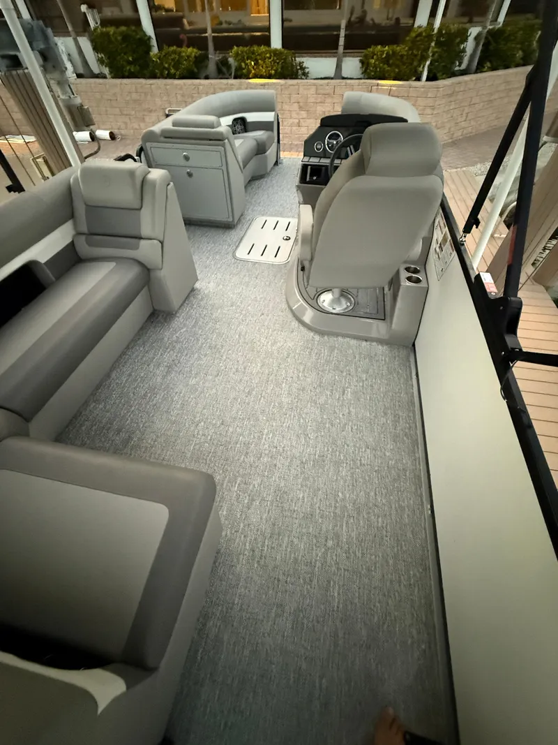 Slide: The Image of 2024 Premier Sunsation 230 RE boat interior with gray seating and modern dashboard. - 23