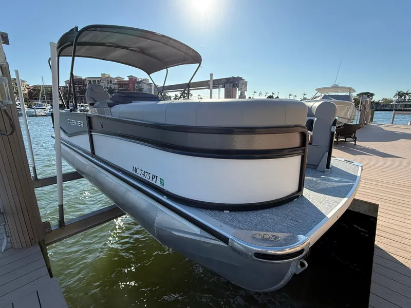 Slide: The Image of 2024 Premier Sunsation 230 RE pontoon boat docked in sunny marina. - 25