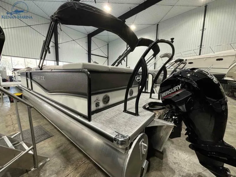 Slide: The Image of 2024 Premier Sunsation 230 RE pontoon boat with Mercury outboard motor in a marina. - 6