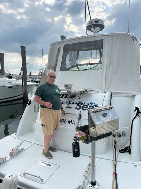 Slide: The Image of Man standing on a 2005 Formula 40 PC boat at a marina. - 15