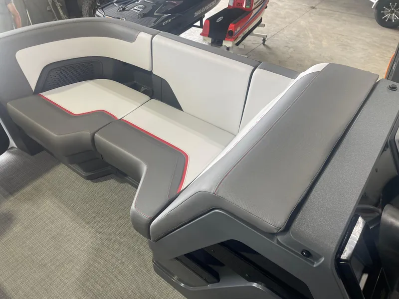 Slide: The Image of 2024 Manitou Cruise boat interior seating with gray and white upholstery. - 12