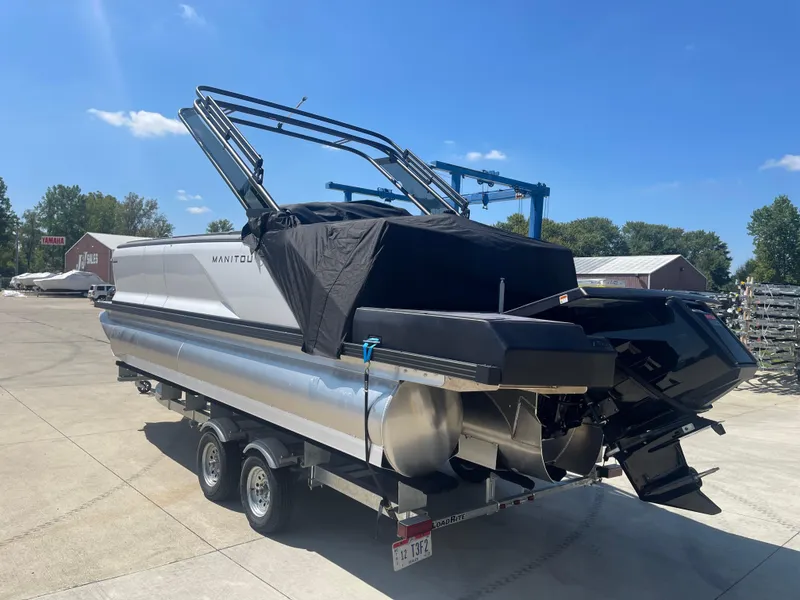 Slide: The Image of 2024 Manitou Cruise pontoon boat on a trailer in a sunny outdoor setting. - 3