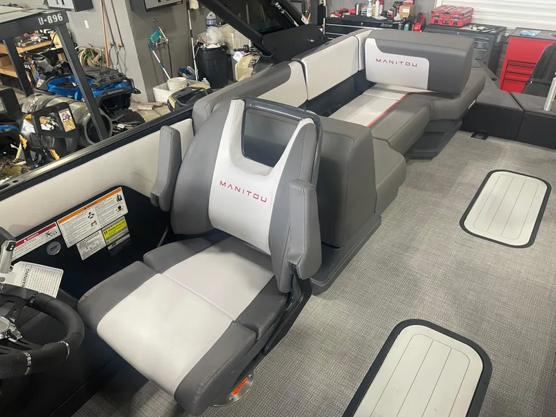 Slide: The Image of 2024 Manitou Cruise boat interior with gray and white seating in a workshop. - 6