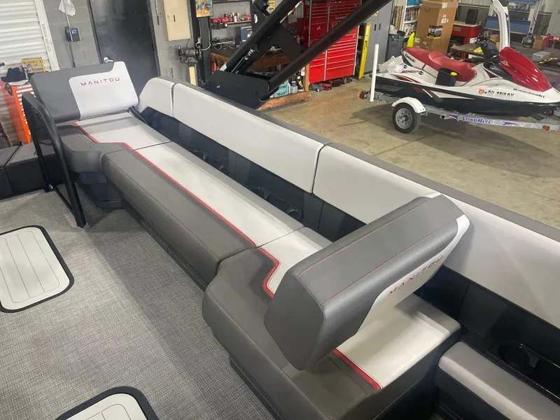 Slide: The Image of 2024 Manitou Cruise boat interior with gray and white seating in a workshop. - 7