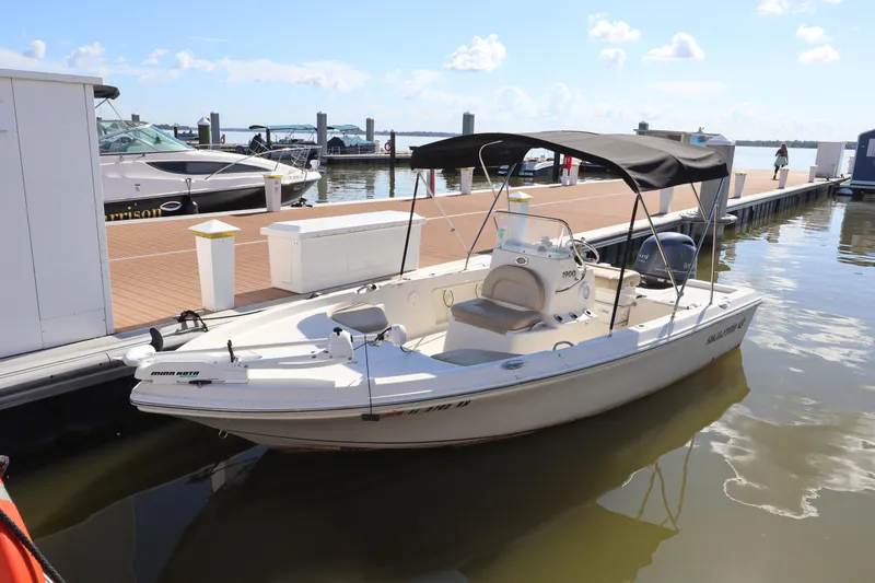 Slide: The Image of 2018 Sailfish 1900 BB Bay Boat docked at a marina under a sunny sky. - 6