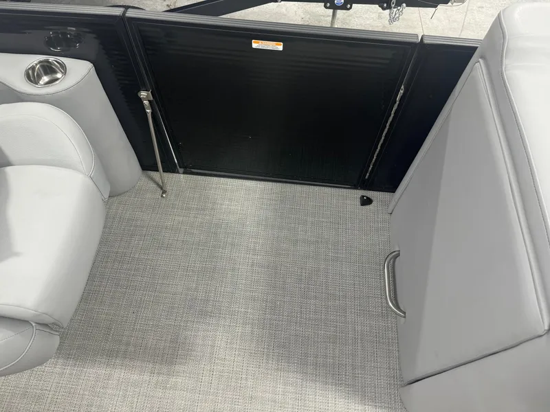 Slide: The Image of 2024 Manitou 25 LX RF interior with gray seating and carpeted flooring. - 10