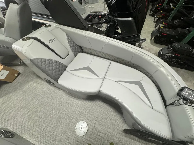 Slide: The Image of 2024 Manitou 25 LX RF boat interior with gray cushioned seating and quilted accents. - 11