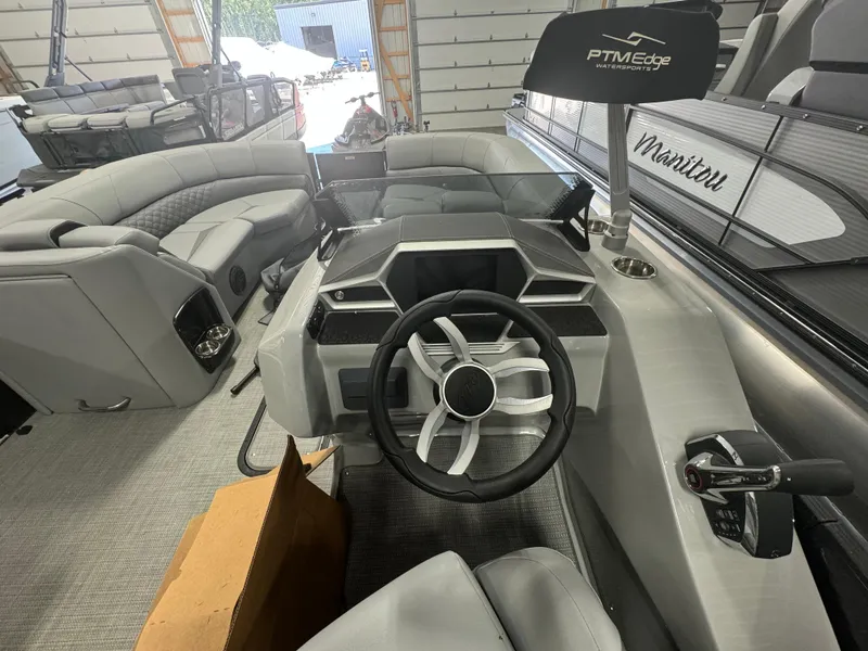 Slide: The Image of 2024 Manitou 25 LX RF boat interior with modern steering wheel and seating. - 15