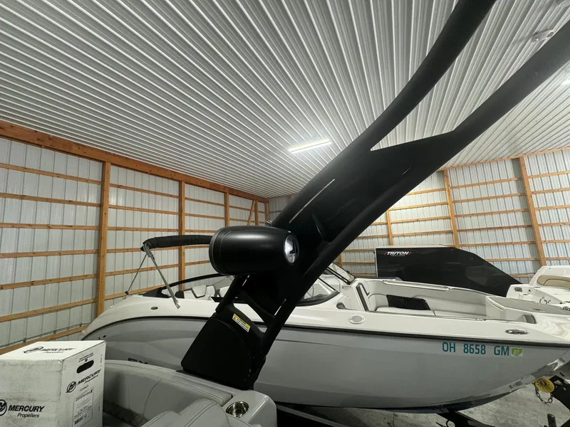 Slide: The Image of 2024 Manitou 25 LX RF boat in storage, featuring sleek design and modern amenities. - 18