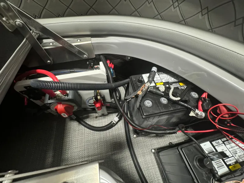 Slide: The Image of 2024 Manitou 25 LX RF boat battery compartment with wiring and connections. - 19