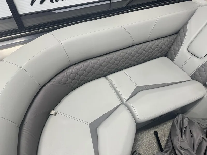 Slide: The Image of 2024 Manitou 25 LX RF boat interior with luxurious gray seating and quilted design. - 2