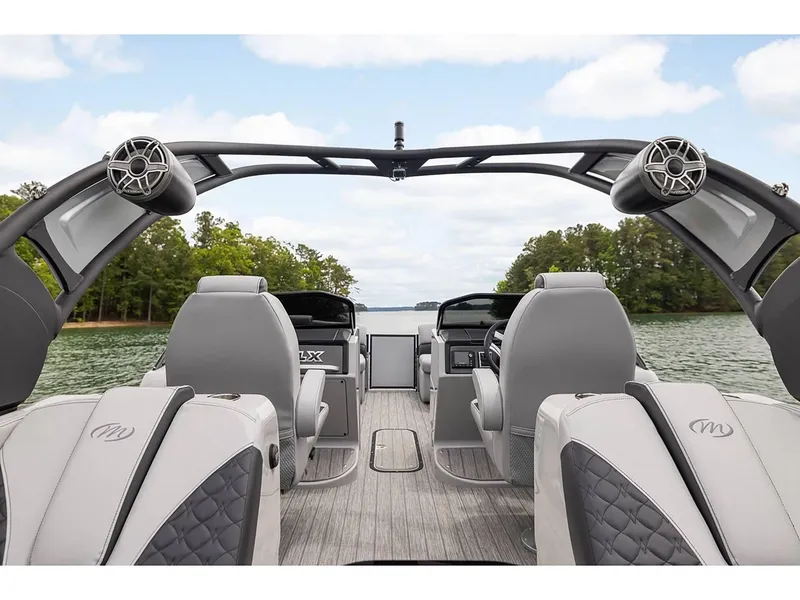 Slide: The Image of 2024 Manitou 25 LX RF pontoon boat interior with luxury seating and lake view. - 21