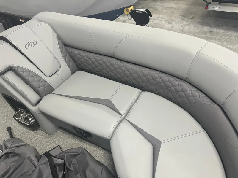 Slide: The Image of 2024 Manitou 25 LX RF boat interior with luxurious gray seating and quilted design. - 3