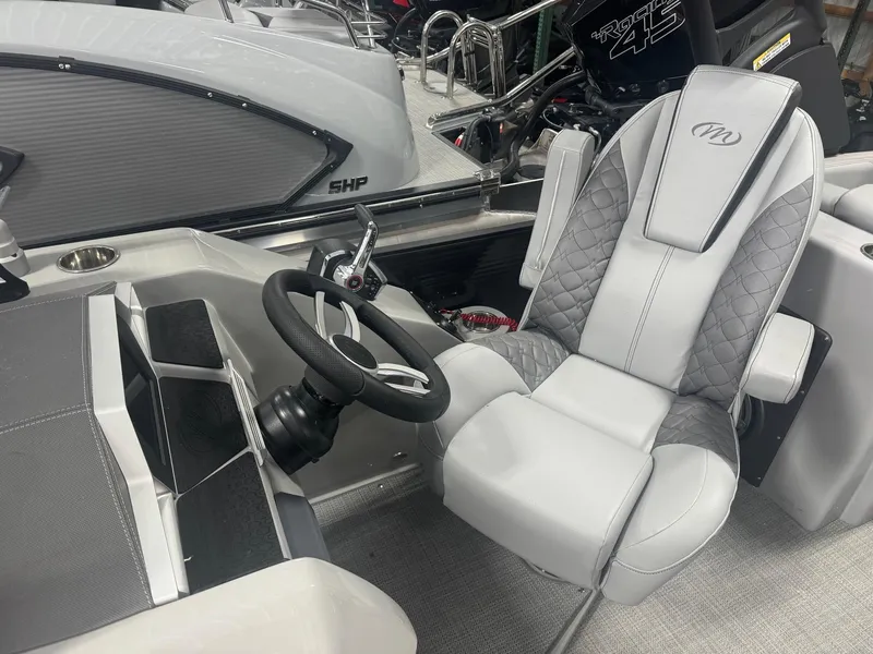Slide: The Image of 2024 Manitou 25 LX RF boat interior with steering wheel and luxurious seating. - 4