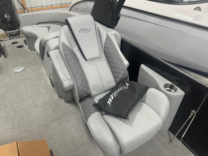 Slide: The Image of 2024 Manitou 25 LX RF boat interior with luxurious gray seating and quilted design. - 9