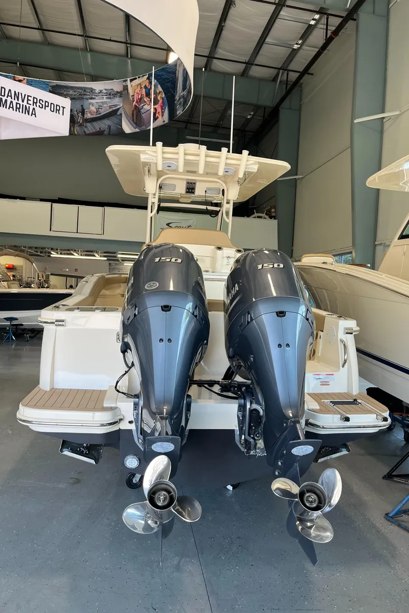 Slide: The Image of 2020 Scout 255 LXF boat with twin outboard engines in a marina showroom. - 4
