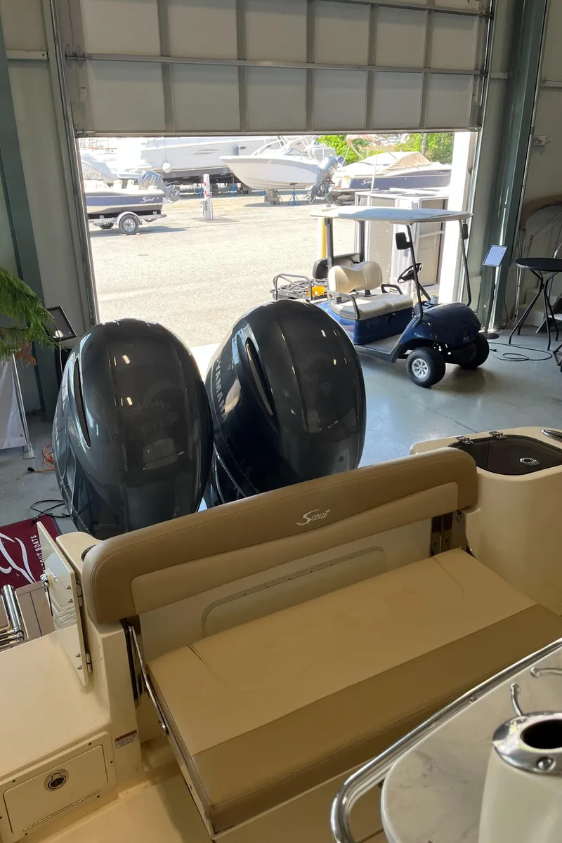 Slide: The Image of 2020 Scout 255 LXF boat with dual outboard engines in a garage. - 6