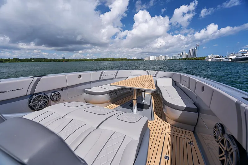 Slide: The Image of 2018 Midnight Express 43 Open boat with spacious seating and table on a sunny day. - 35